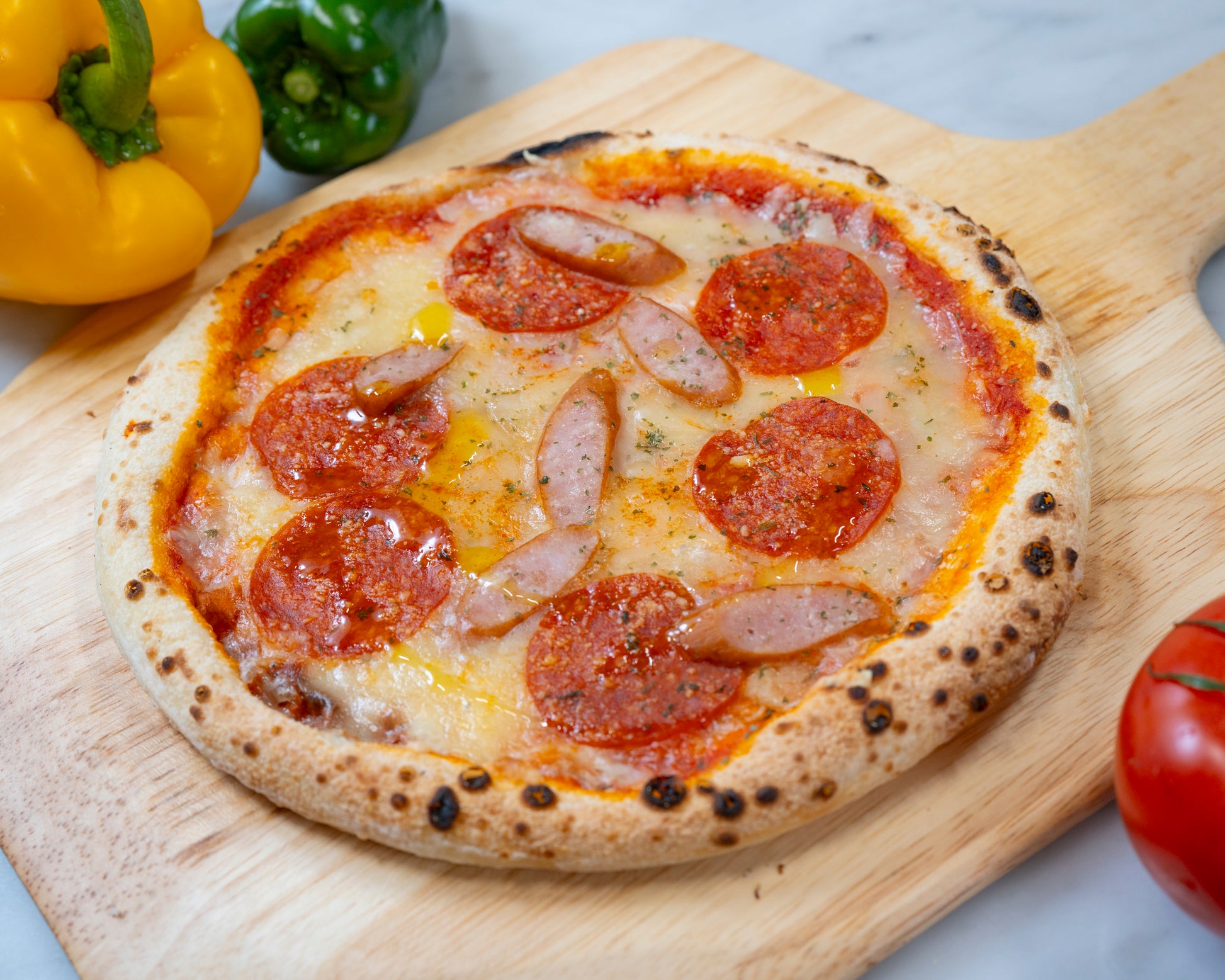 ウィンナーサラミ｜ プリッとしたウインナーと、スパイスの効いたサラミの旨み。本格的な小麦の風味を最大限に活かすよう、２種の肉のバランスが絶妙に調和した、食べ応えのある王道ピザ。